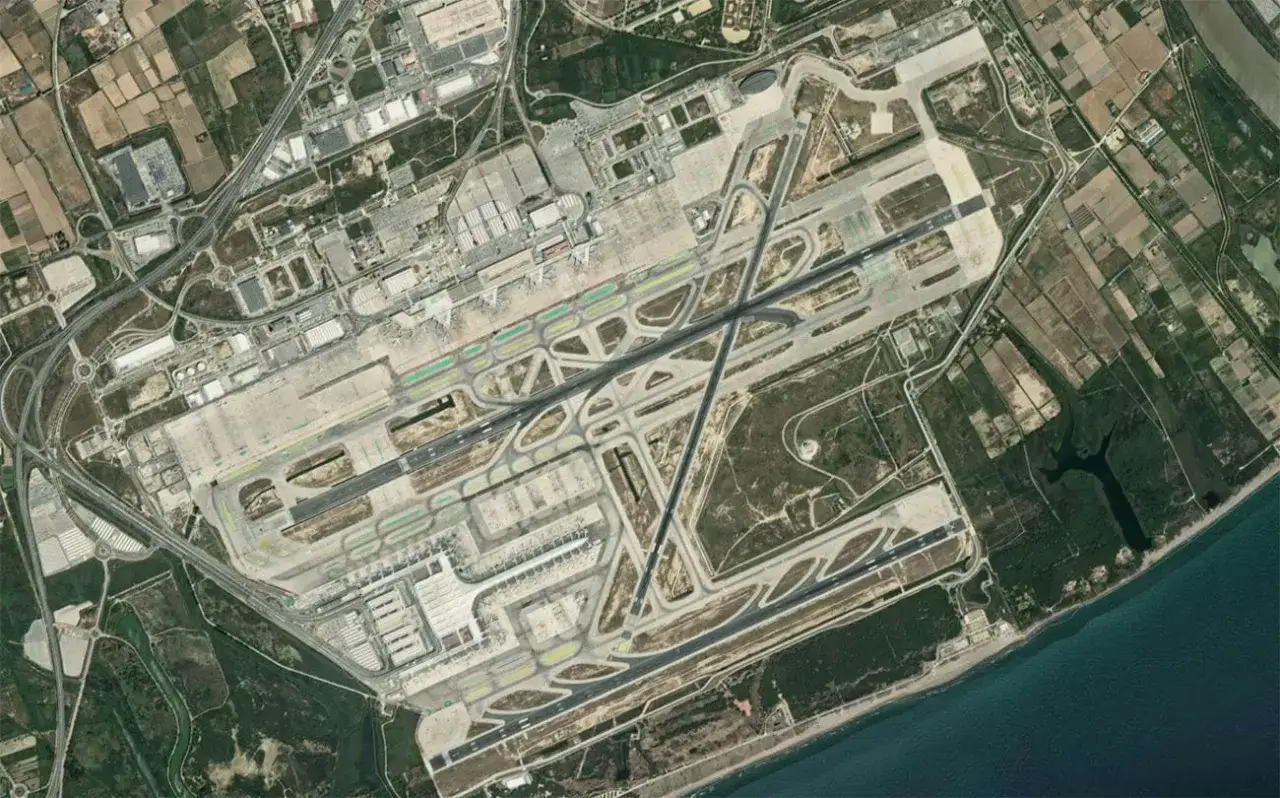 Widok z lotu ptaka na lotnisko Barcelona El Prat z pasami startowymi, terminalami i drogami.