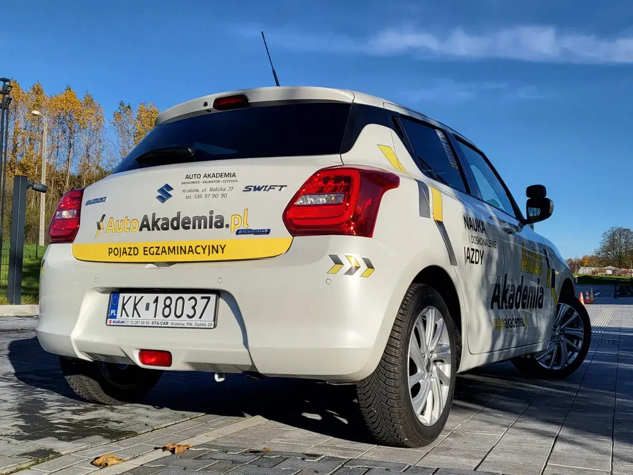 Biały Suzuki Swift z napisem 