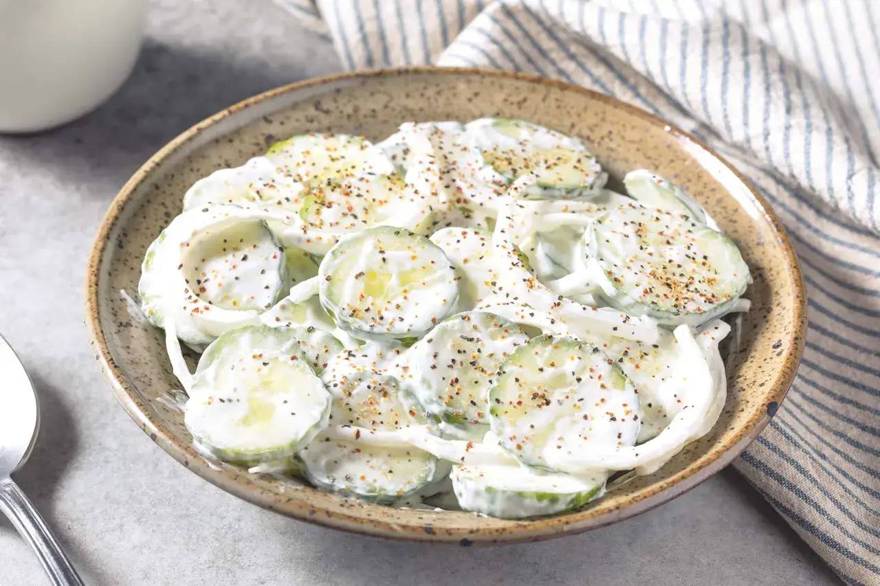 Salade de concombre à la crème, garnie de poivre noir et d'épices. Une recette fraîche et légère.