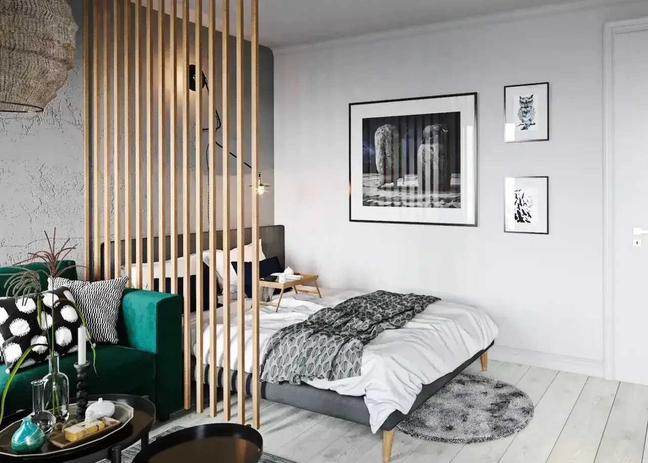 Une chambre moderne avec un s&eacute;parateur en bois pour s&eacute;parer une chambre pour 2 ados. Un canap&eacute; vert, un lit, et des tableaux aux murs.