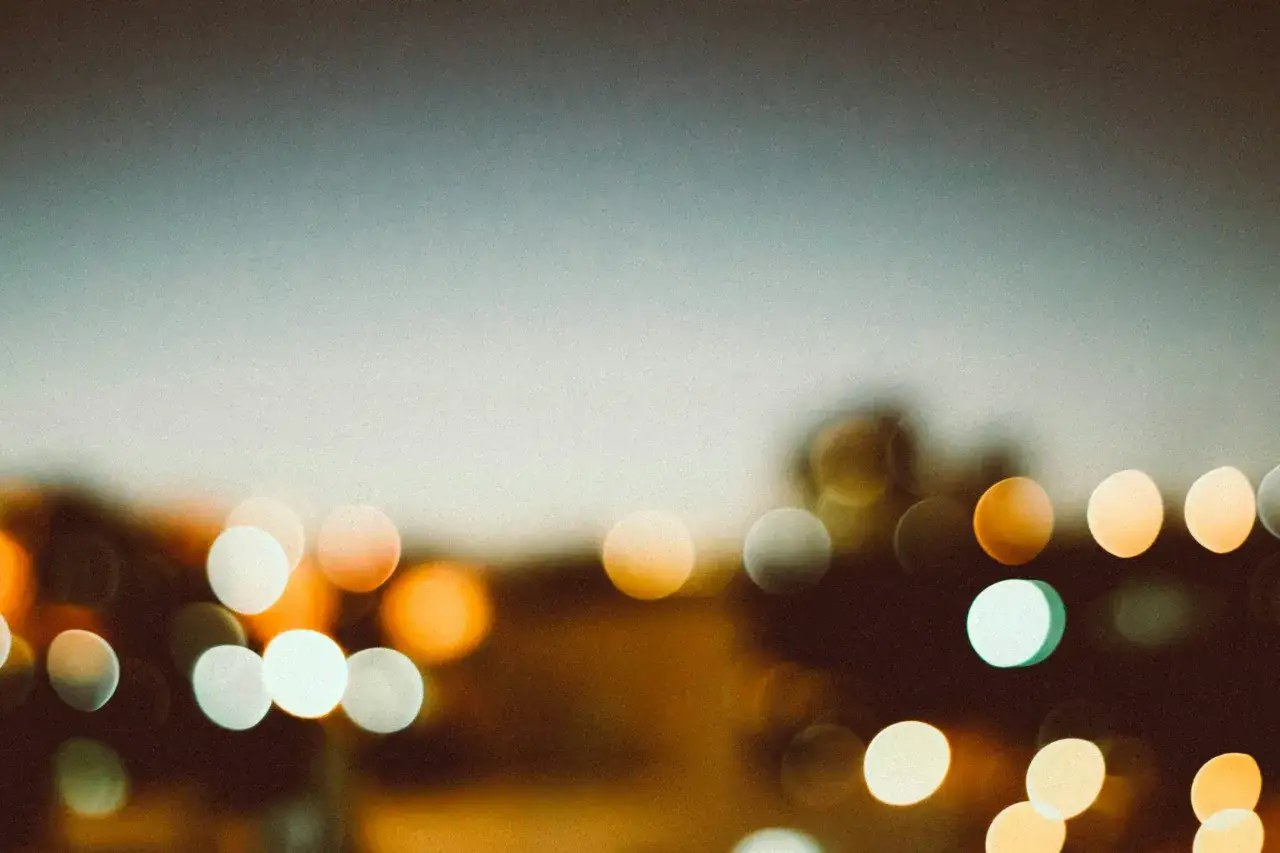 Rozmyte światła miasta tworzą efekt bokeh. To artystyczne rozmycie tła, kt&oacute;re sprawia, że punkty światła stają się okręgami.