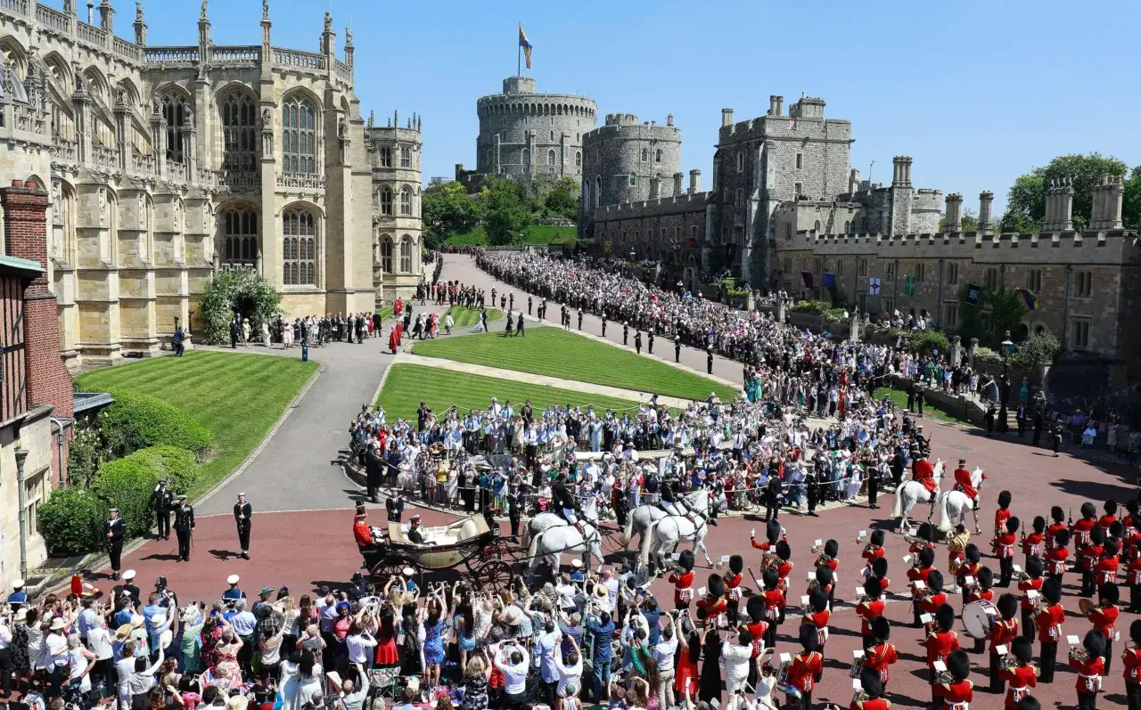 C&eacute;r&eacute;monie du mariage de Harry et Meghan &agrave; Windsor. Une foule immense acclame le couple royal dans une cal&egrave;che, entour&eacute;e de gardes et de la chapelle Saint-Georges.