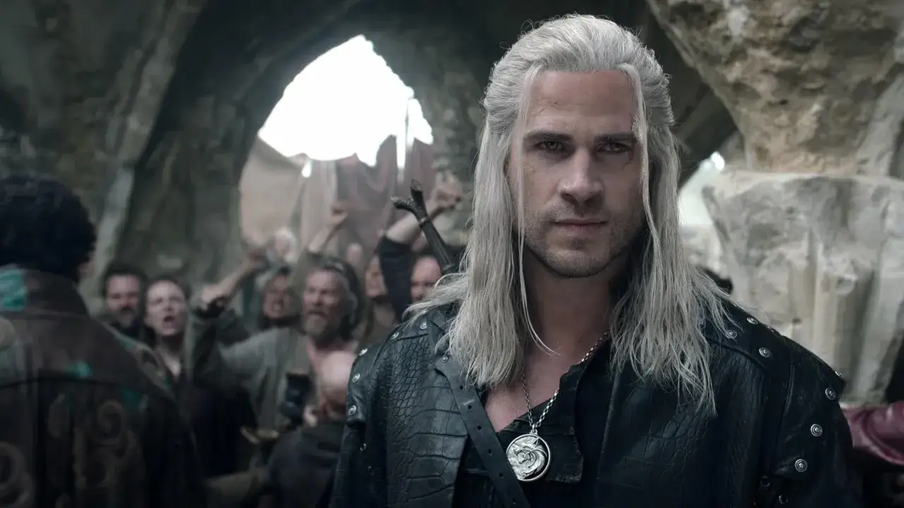 Henry Cavill som Geralt i The Witcher, med en arg folkmassa i bakgrunden.