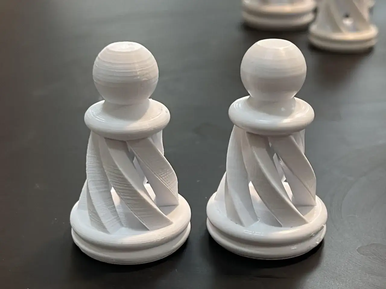 Pedine degli scacchi bianche stampate in 3D con un design a spirale, realizzate in pla acetone.