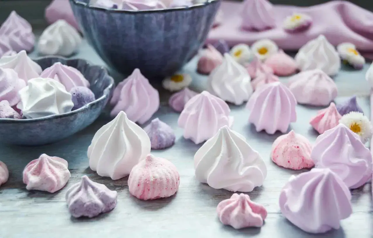 Zarte Baiser in Rosa, Lila und Wei&szlig;, wie aus einem Baiser Rezept. Kleine, luftige Kunstwerke, die zum Naschen einladen.