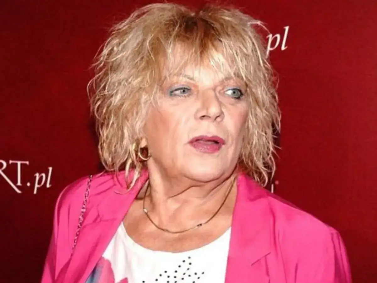 Dorota Stalińska w różowej marynarce, z burzą blond włosów. Mówi o swoim mężu.