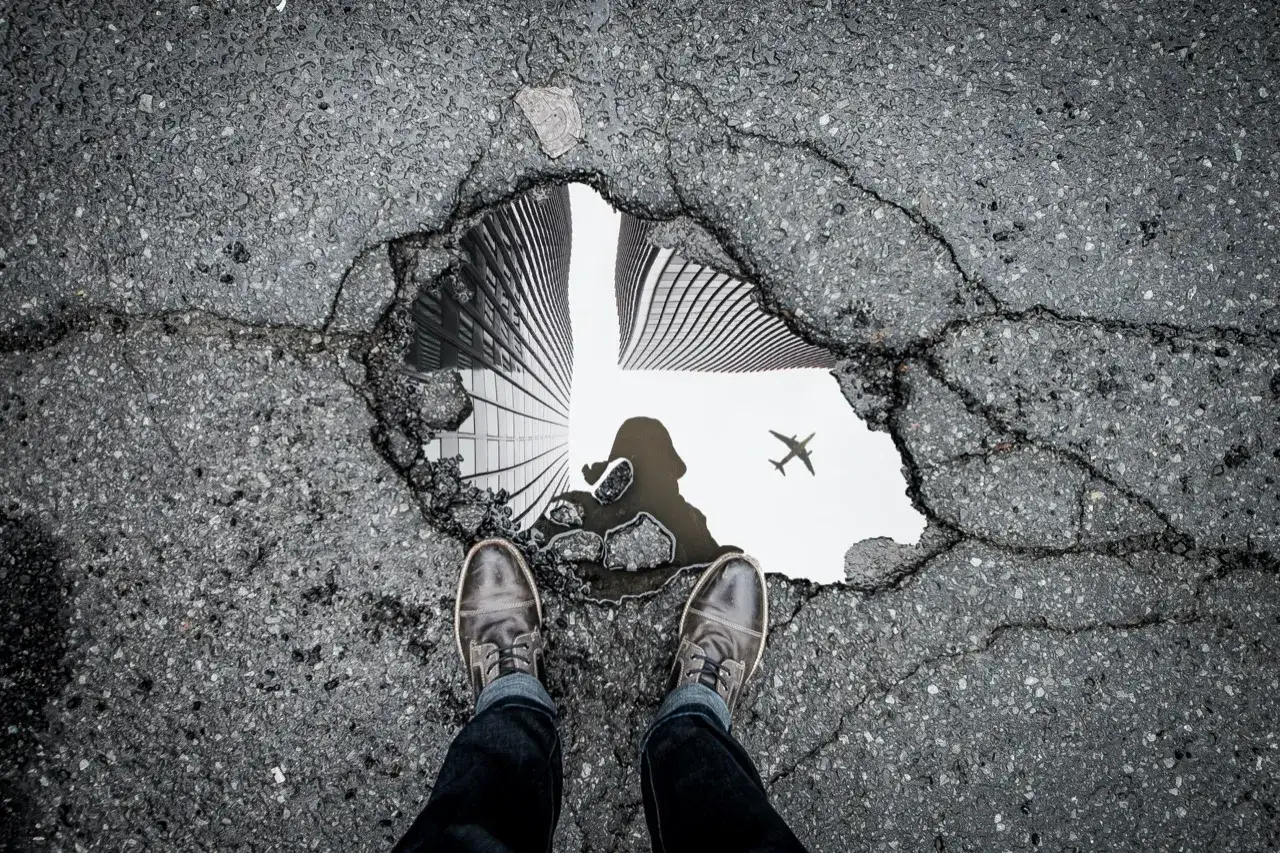 Une flaque d'eau refl&egrave;te des gratte-ciel et un avion. Ce th&egrave;me de photo, 