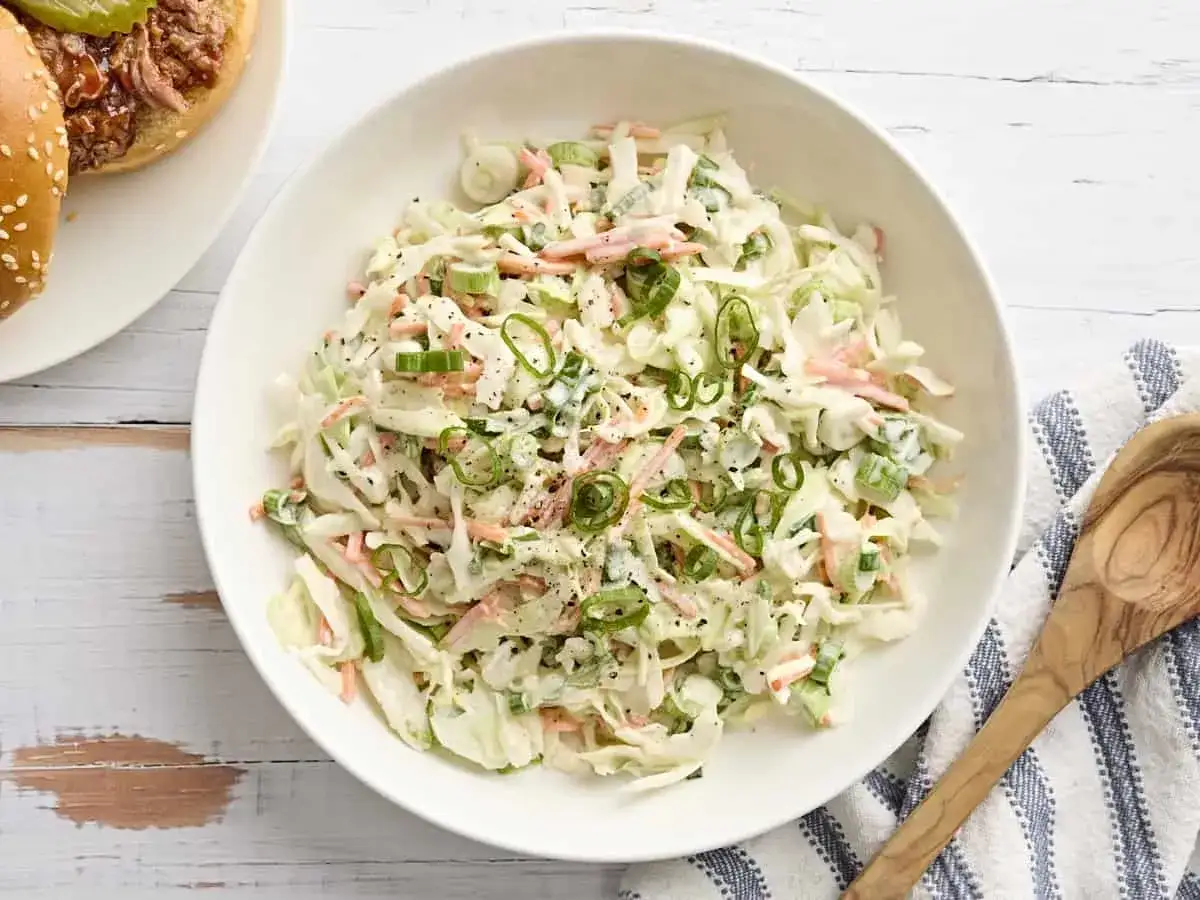 Cremiger Krautsalat mit Karotten und Fr&uuml;hlingszwiebeln, perfekt f&uuml;r Ihr coleslaw rezept. Daneben ein Burger mit Pulled Pork.