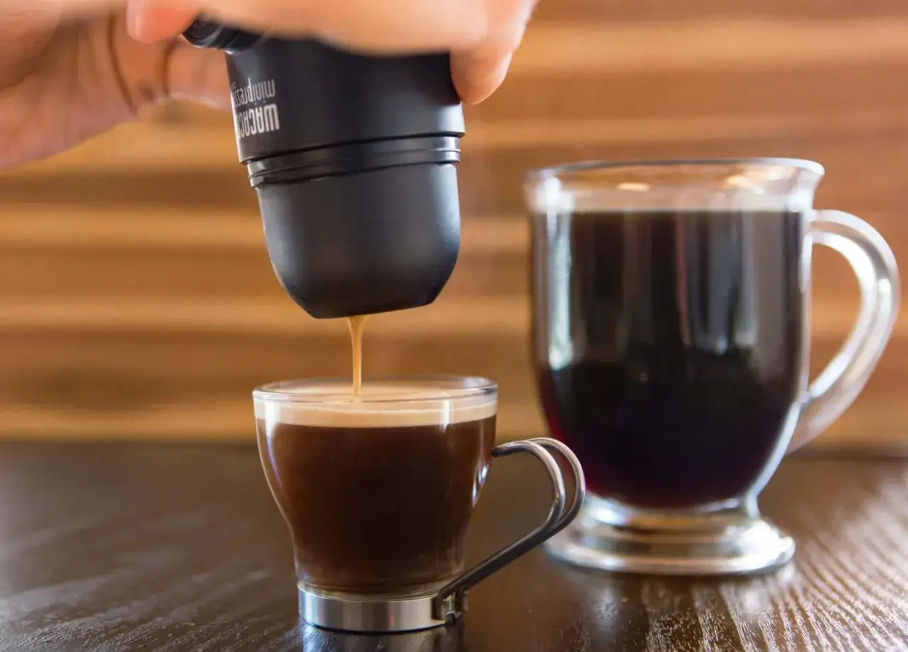 Un caffè espresso viene versato in una tazza, creando la base per un caffè americano.