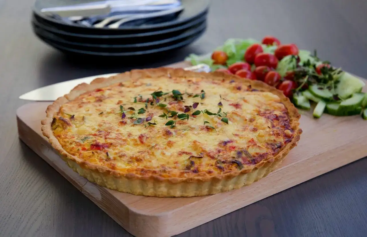 Leilas kycklingpaj, gyllene och gratinerad, serveras med en fräsch sallad av tomater och gurka.