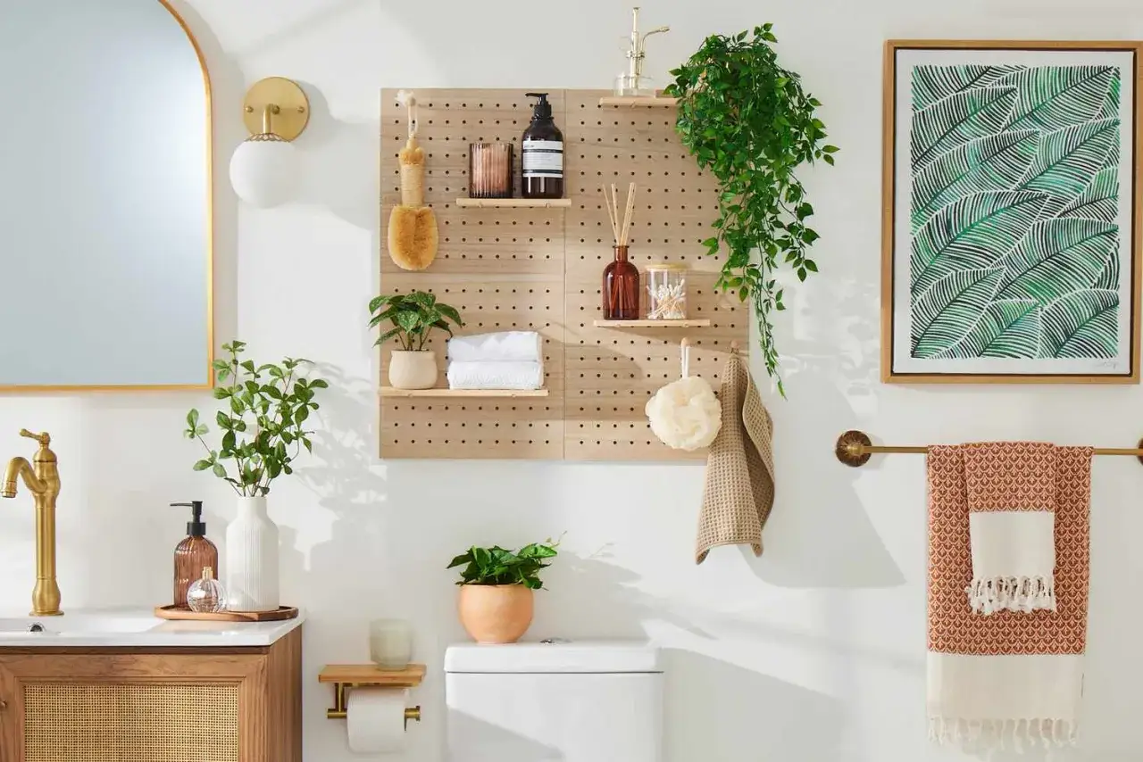 Ambiance zen dans cette petite salle de bain avec un porte-serviettes, des plantes et un tableau végétal.