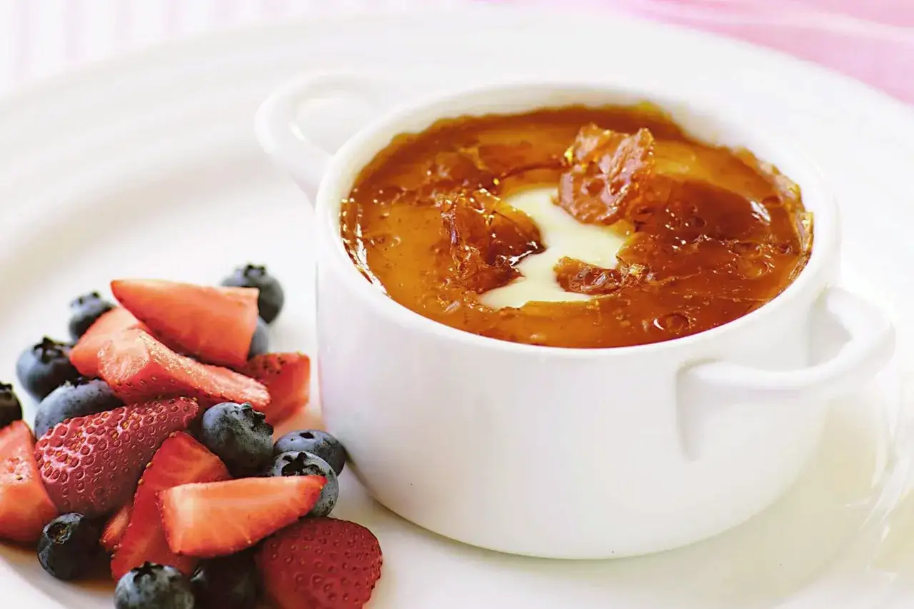 Creme brulee mit karamellisierter Kruste und frischen Beeren. Was passt zu Creme brulee? Frische Erdbeeren und Blaubeeren sind eine k&ouml;stliche Erg&auml;nzung.