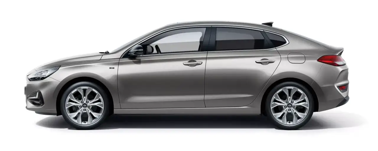 Elegancki, srebrny i30 Hyundai w wersji Fastback, z przyciemnianymi szybami i stylowymi felgami.