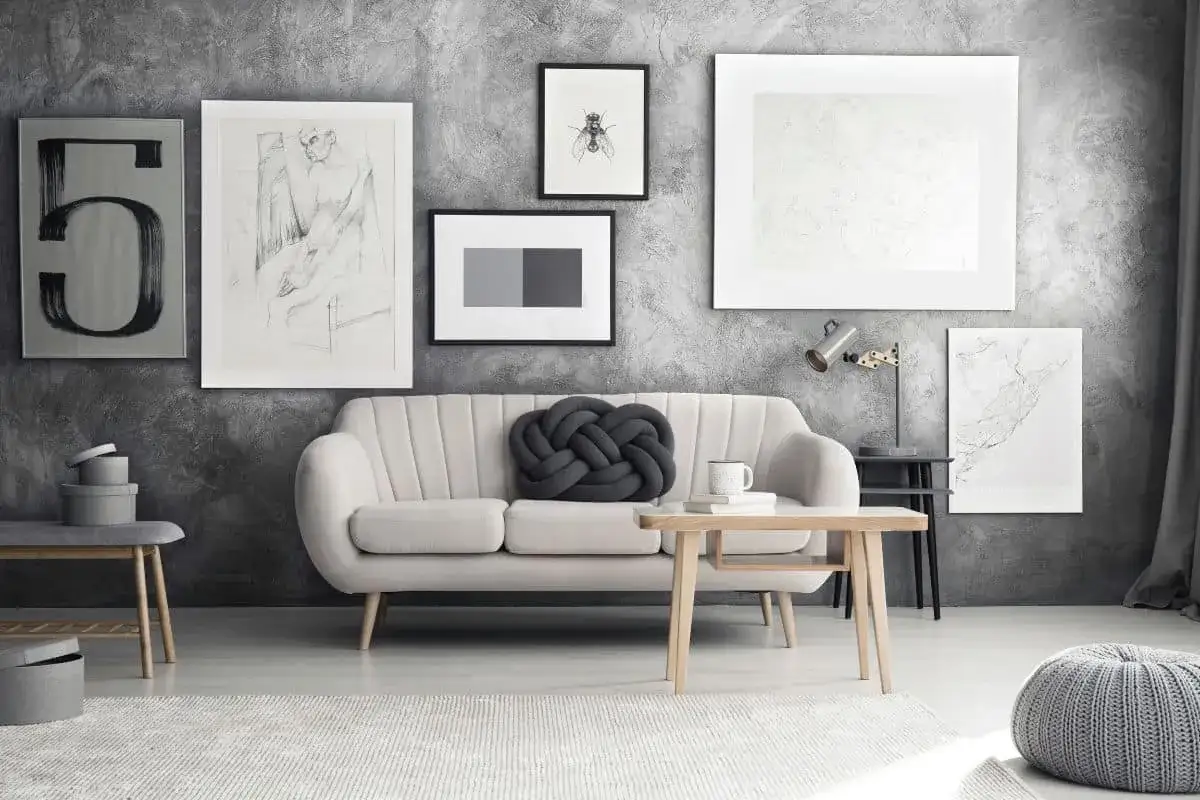 Szara sofa z jasnym stolikiem i dekoracjami. Jaki kolor pasuje do srebrnego? W tym wnętrzu dominują odcienie szarości i bieli, tworząc spójną, nowoczesną aranżację.