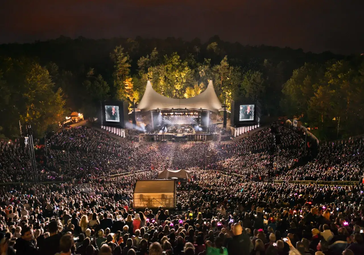 Ein riesiges Publikum feiert Roland Kaiser in Berlin. Die Waldbühne ist voller Menschen, die auf die Bühne blicken.