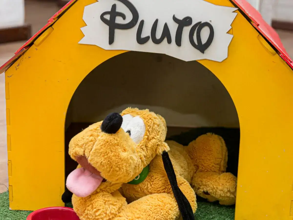 Pluszowy piesek Pluto, jeden z ulubionych bohaterów bajek, odpoczywa w swojej żółtej budzie.