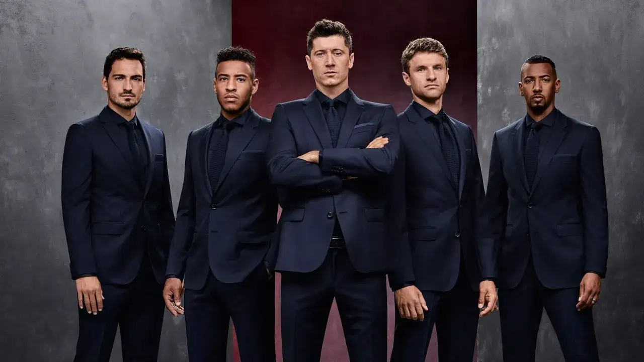 Pięciu mężczyzn w granatowych garniturach, prezentujących elegancję marki Hugo Boss.