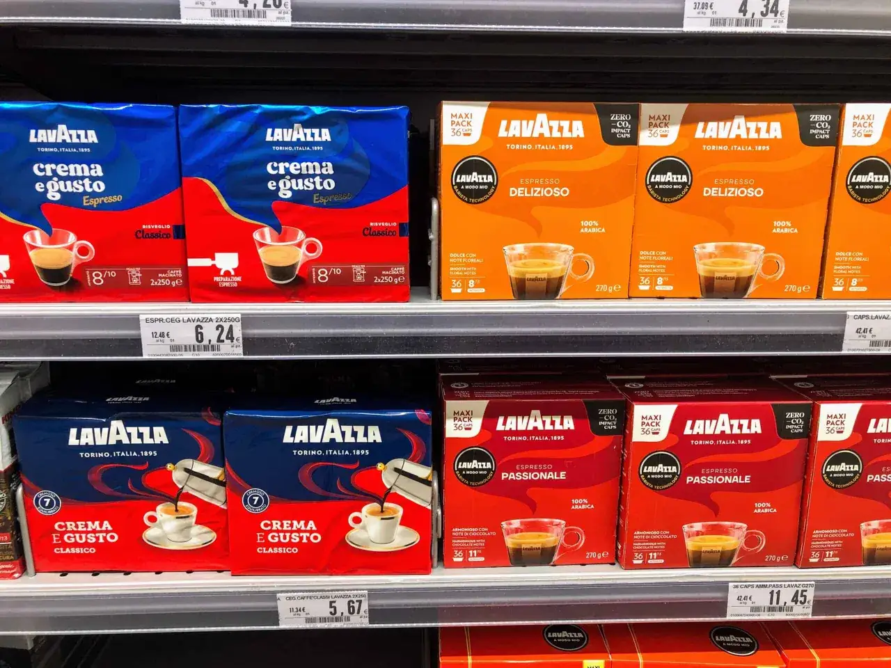 Włoskie marki kawy Lavazza na półce sklepowej: opakowania Crema e Gusto i Espresso Passionale.