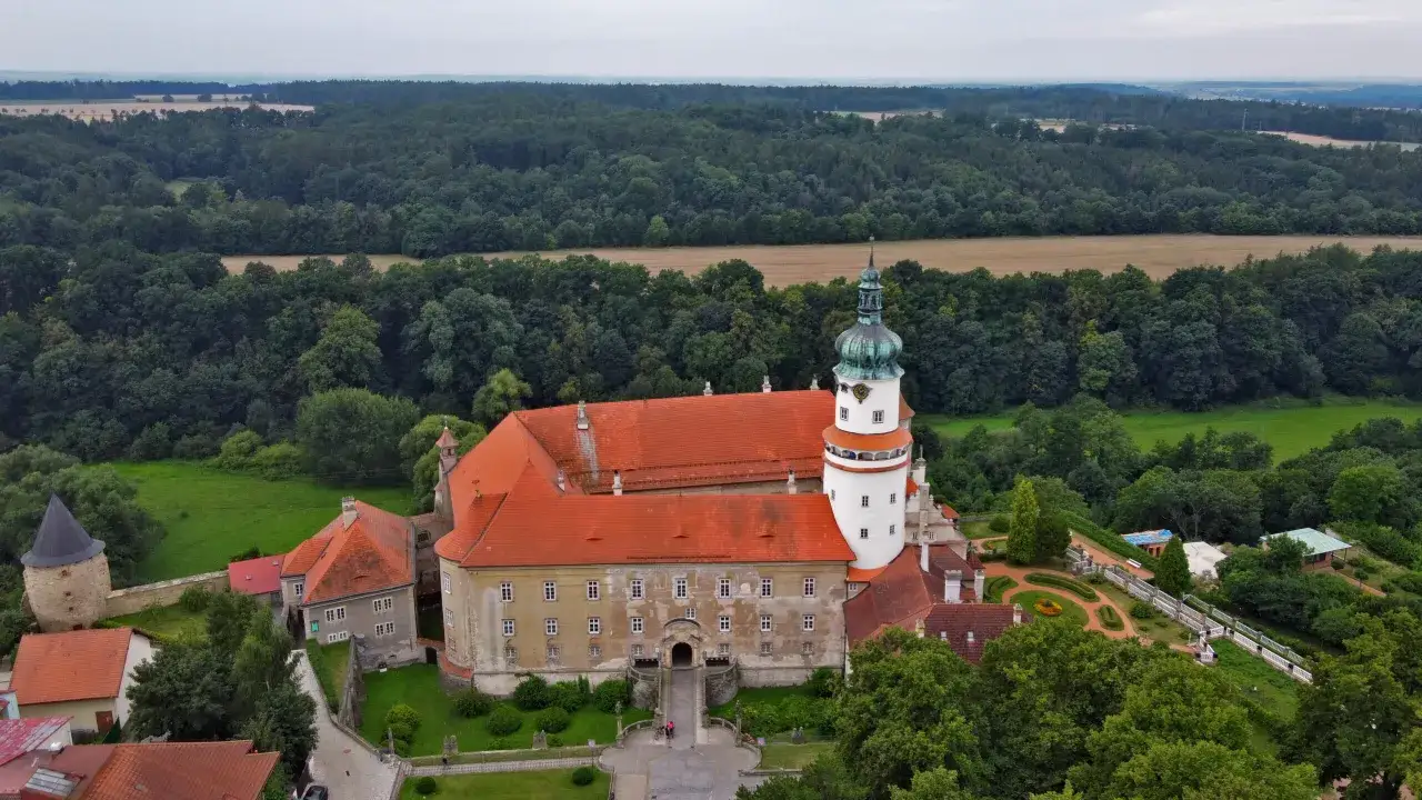 Zamek Loučeň, jeden z najpiękniejszych miejsc w Czechach, otoczony zielenią i lasami, z charakterystyczną wieżą i oranżerią.