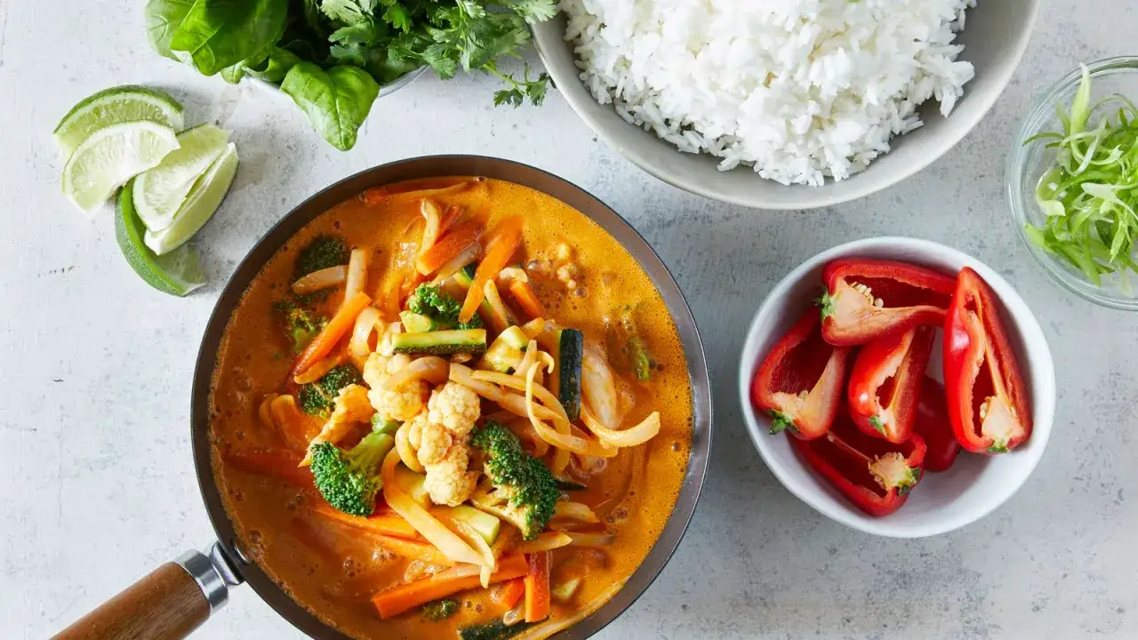 Aksamitny, aromatyczny **thai red curry** z warzywami: brokułami, marchewką, cukinią i kalafiorem, podany z ryżem.