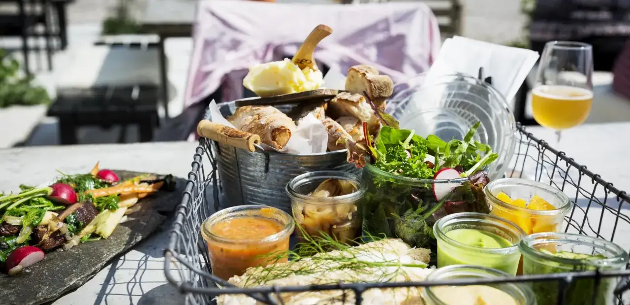 En korg med godsaker fr&aring;n annorlunda restauranger i Sk&aring;ne: f&auml;rsk fisk, sallad, br&ouml;d, sm&ouml;r och olika r&ouml;ror.