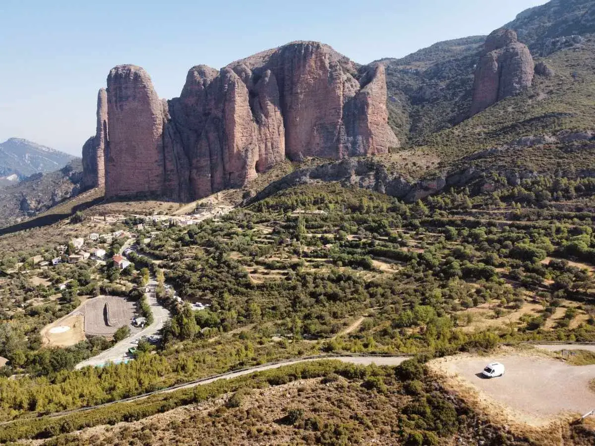 Paysage spectaculaire pour un circuit touristique en Aragon, Espagne : falaises imposantes, village pittoresque et végétation luxuriante.