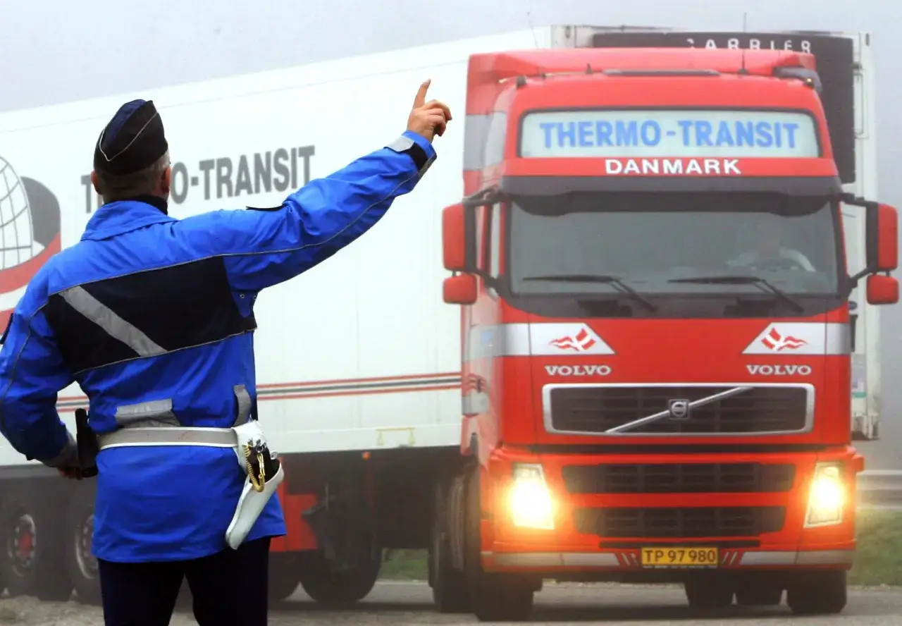 Un agent de police contr&ocirc;le le temps de conduite et de repos d'un camion Thermo-Transit Danemark.