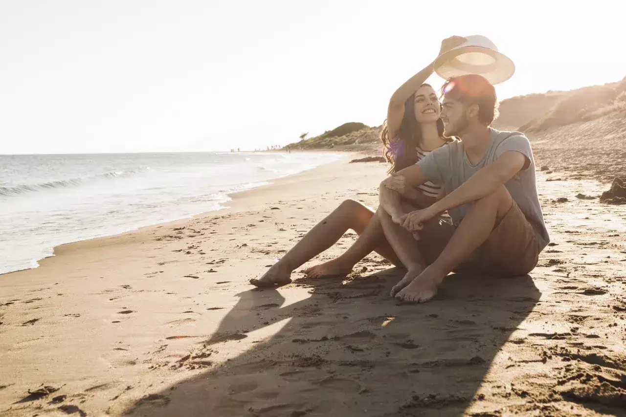 Pareja disfrutando de un atardecer en la playa, ideal para saber qué hacer en Nerja en pareja.