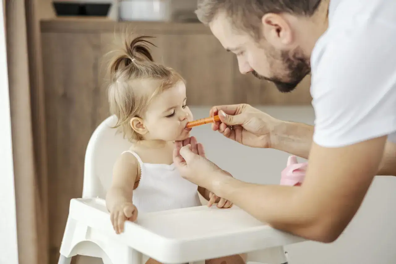 Tata podaje dziecku syrop z pomocą strzykawki. Cierpliwość to klucz, jak podać dziecku syrop gdy nie chce.