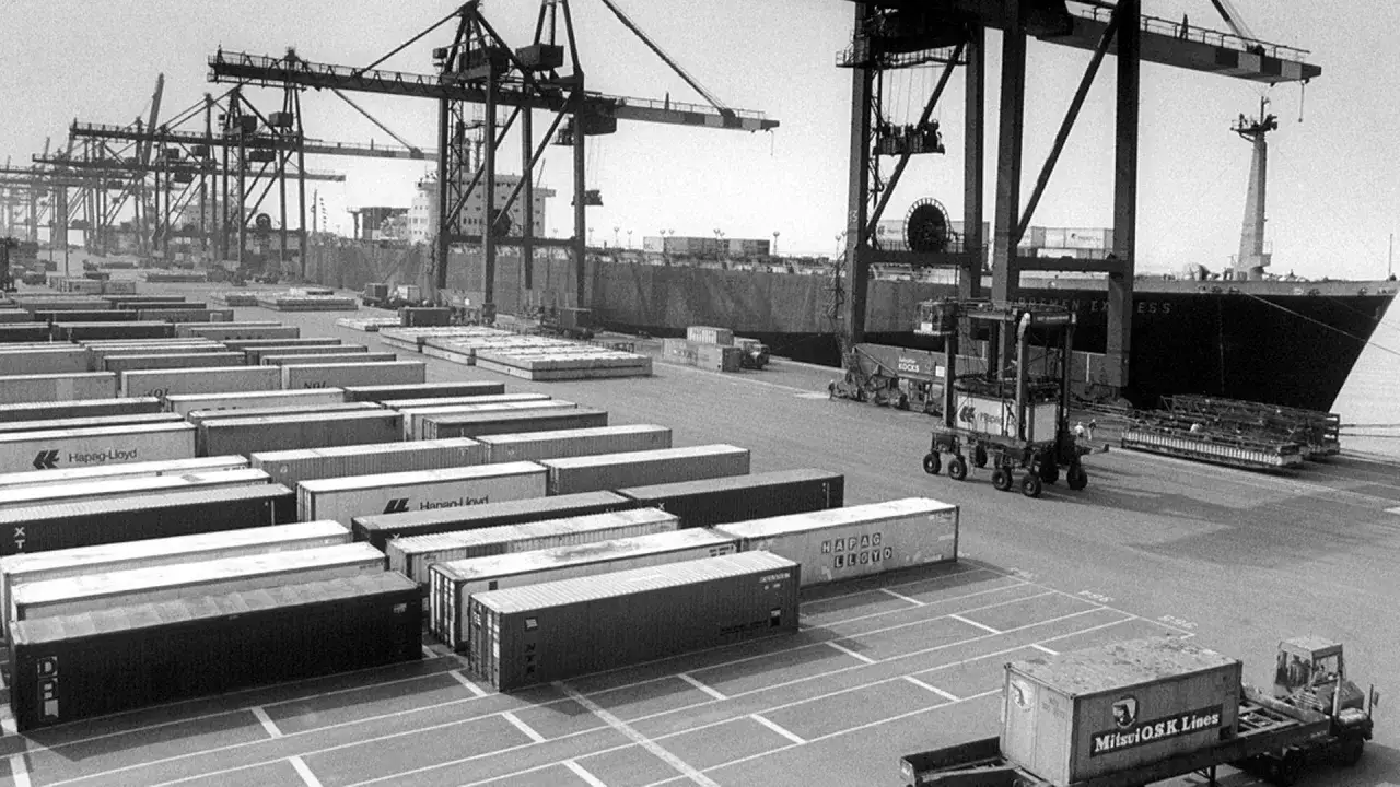 Ein gesch&auml;ftiger Containerhafen mit vielen vgm container, Kr&auml;nen und einem Frachtschiff.