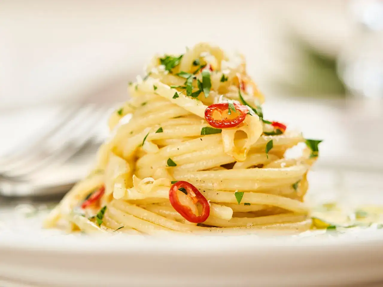 Ein Berg von Spaghetti Aglio e Olio, garniert mit frischer Petersilie und scharfen Chilischeiben.