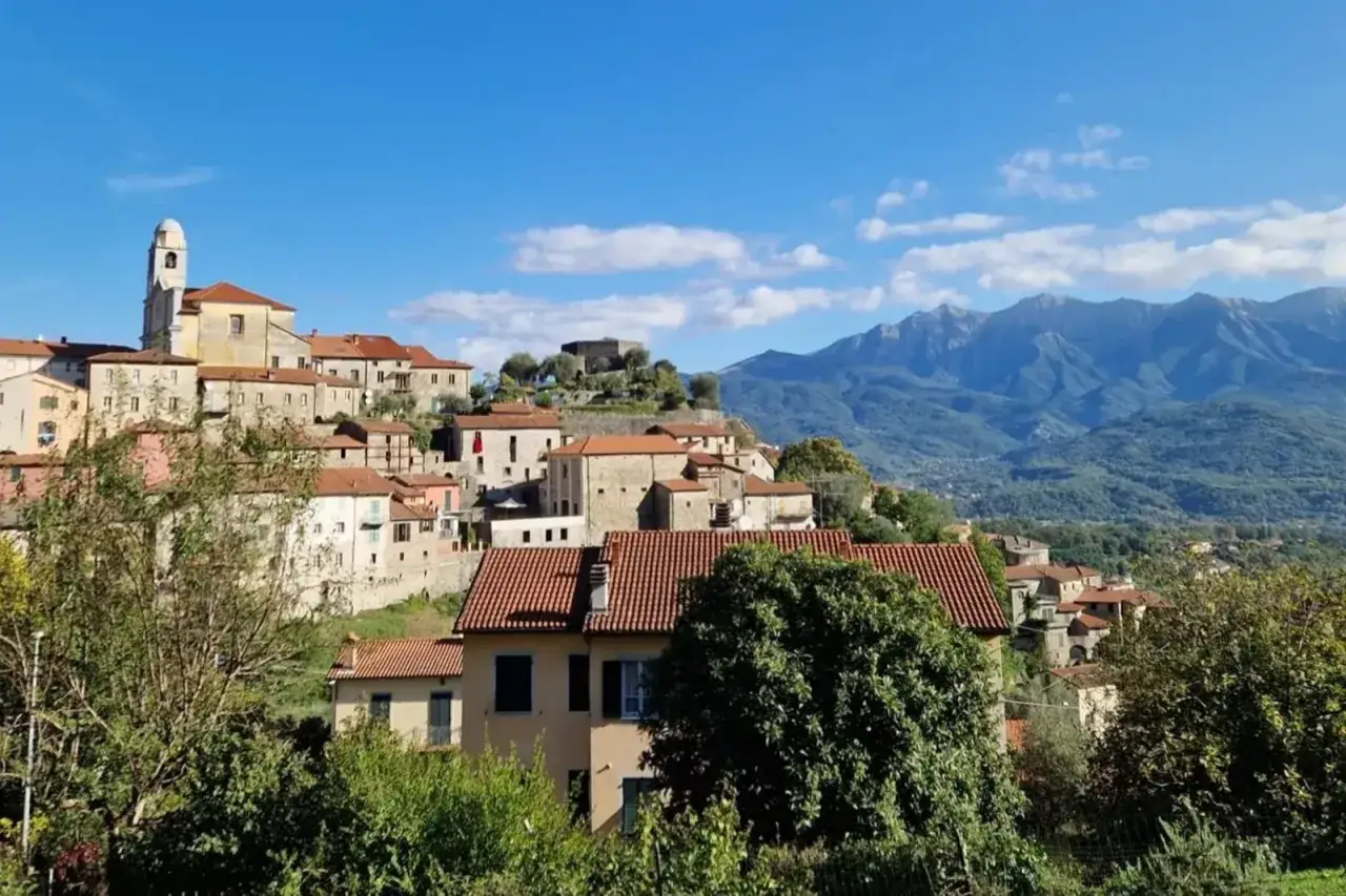 Mulazzo: borgo collinare con case in pietra, campanile e castello, incorniciato da montagne. Cosa vedere in questo incantevole paesaggio.