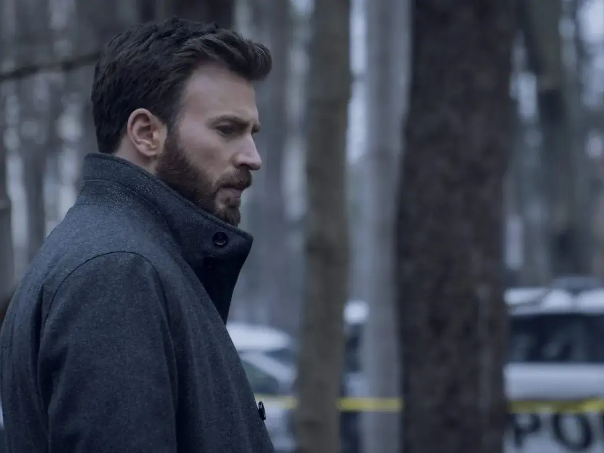 Chris Evans w ciemnym płaszczu, w tle policyjne taśmy. Jeden z jego mrocznych **chris evans filmy**.