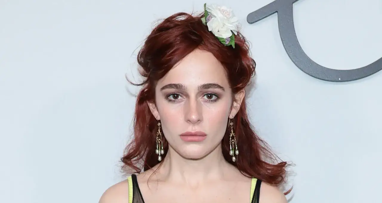 Sophia Anne Caruso mit roten Haaren, Blumen im Haar und auffälligem Schmuck.