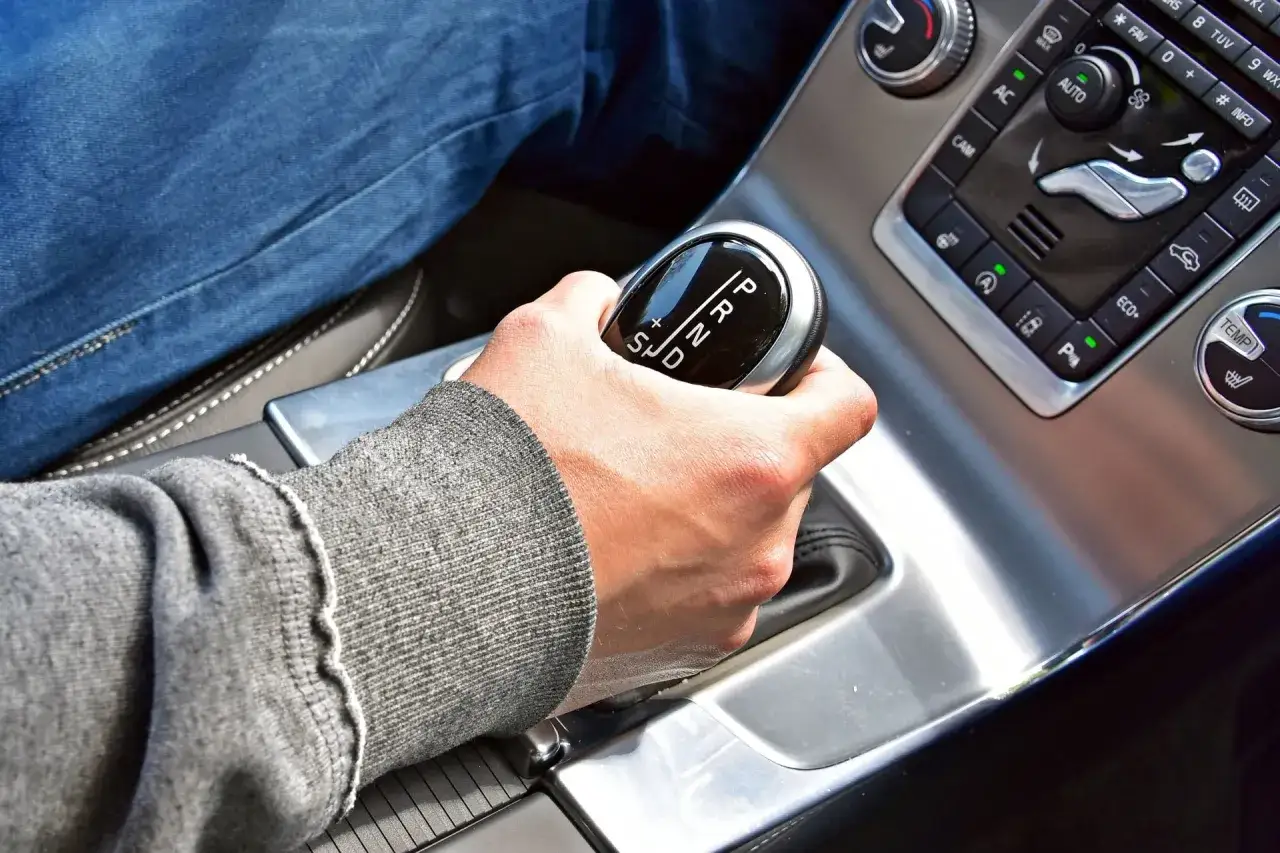 Dłoń na dźwigni zmiany biegów w samochodzie z automatyczną skrzynią. Proste wskazówki, jak jeździć automatem.