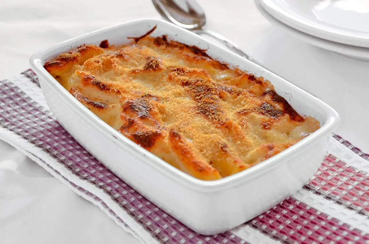 Pasta al forno ricetta della nonna: un piatto dorato e invitante, pronto per essere gustato.
