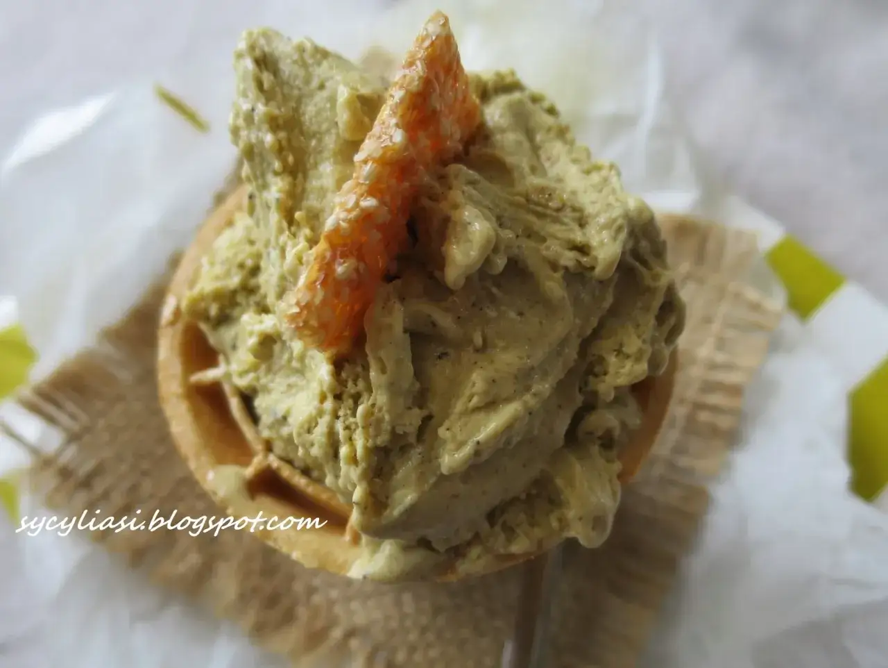 Pistacjowe lody sycylijskie w wafelku, ozdobione kandyzowaną skórką pomarańczy.