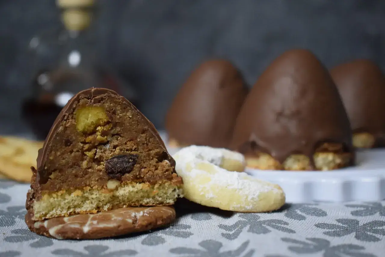 Süße Versuchung: Ein angeschnittener Schoko-Keks mit Nüssen und Rosinen, daneben Vanillekipferl. Ein leckeres granatsplitter rezept.