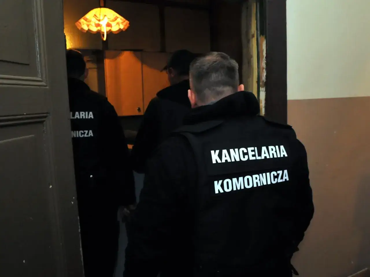 Komornicy w kamizelkach z napisem 