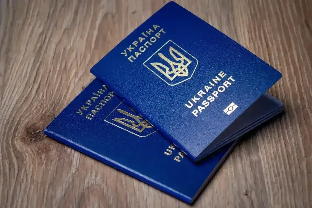 Dwa niebieskie paszporty Ukrainy leżą na drewnianym blacie. Gotowi na podróż do Turcji?