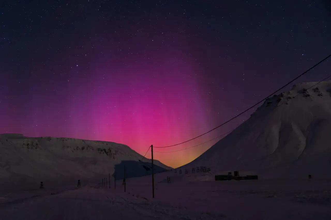 Zimowe wyprawy na Spitsbergen to spektakl zorzy polarnej nad ośnieżonymi górami, w przeciwieństwie do łagodniejszych Lofotów.