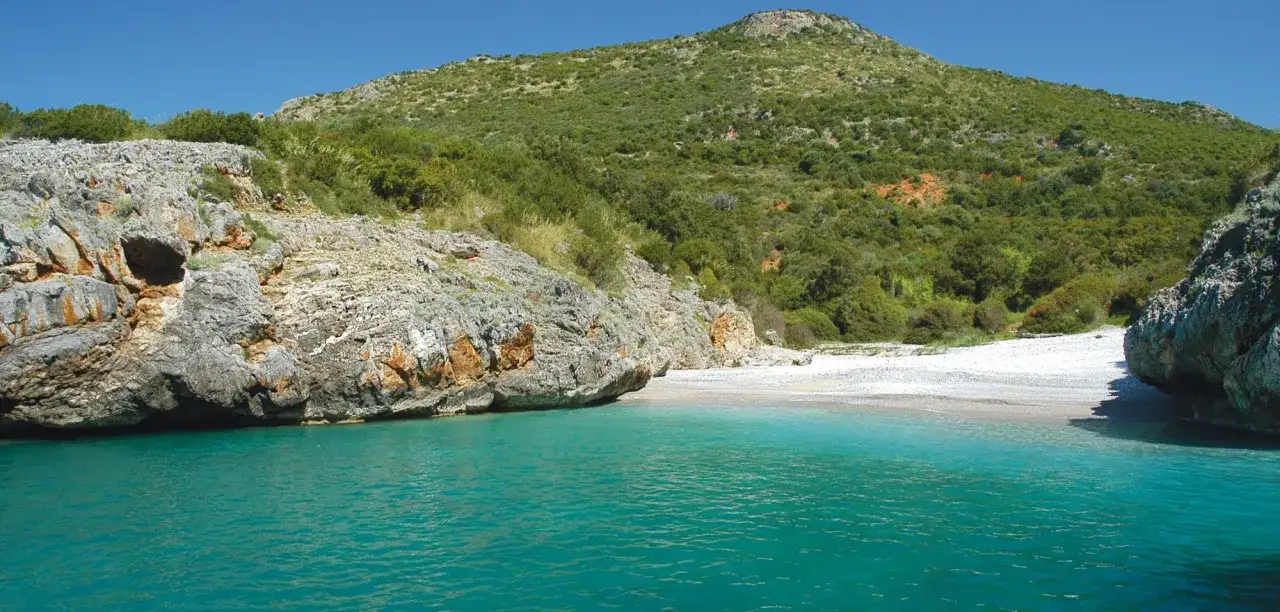 Spiaggia selvaggia con rocce e macchia mediterranea, un angolo di paradiso tra le localit&agrave; di mare pi&ugrave; economiche Italia.