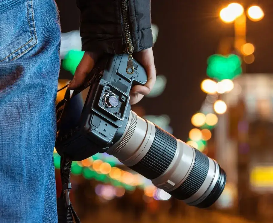 fotograf z teleobiektywem w słabym świetle
