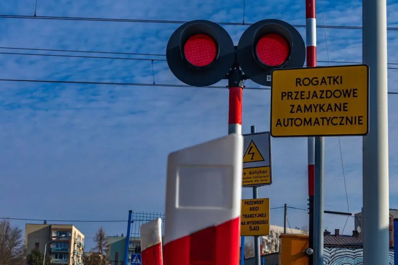 Czerwone światła na przejeździe kolejowym zaporowym oznaczają, że zbliża się pociąg.