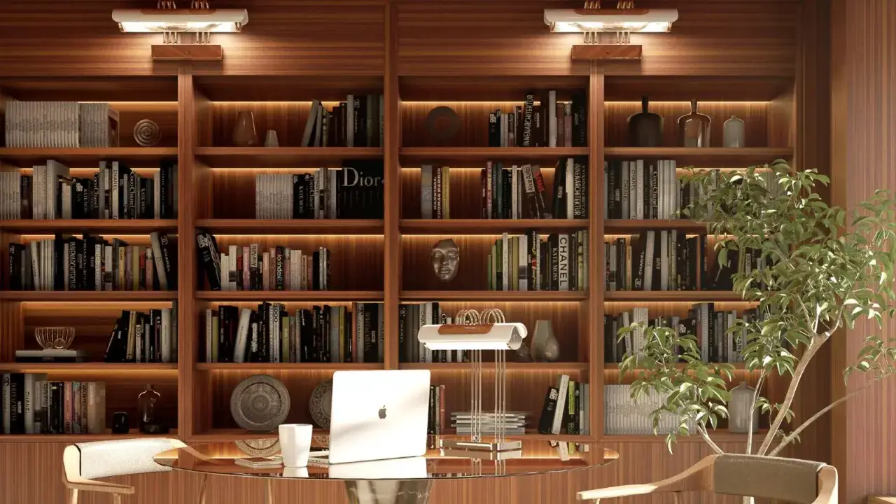 Estanterías de madera repletas de libros, creando un ambiente acogedor en estas casas con biblioteca. Un escritorio moderno con portátil y una lámpara completan la escena.