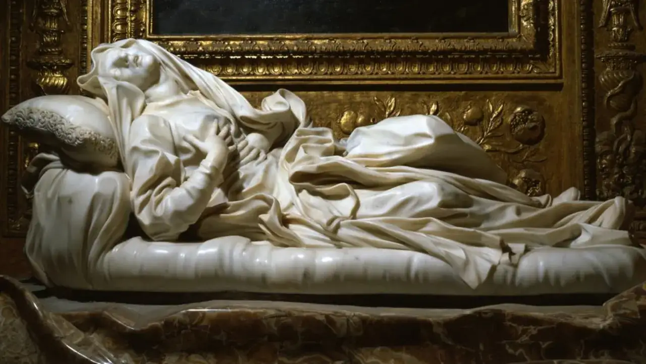 Scultura in marmo bianco raffigurante l'estasi della Beata Ludovica Albertoni, con panneggi fluenti e volto sereno rivolto al cielo.