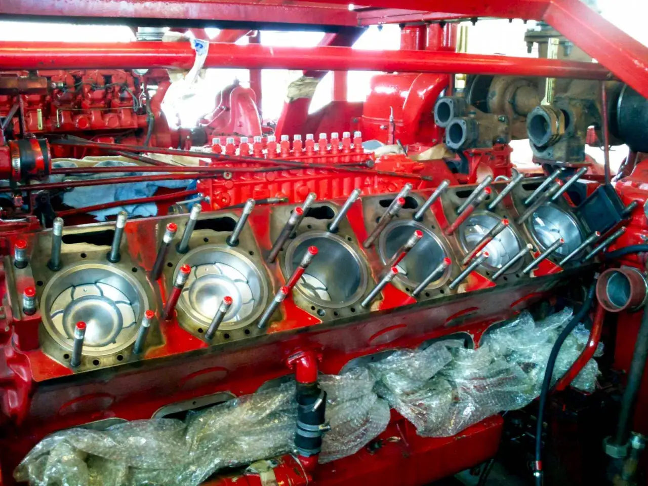 Moteur rouge ouvert, pistons visibles. Si un moteur est noyé, combien de temps attendre avant de le démarrer ?