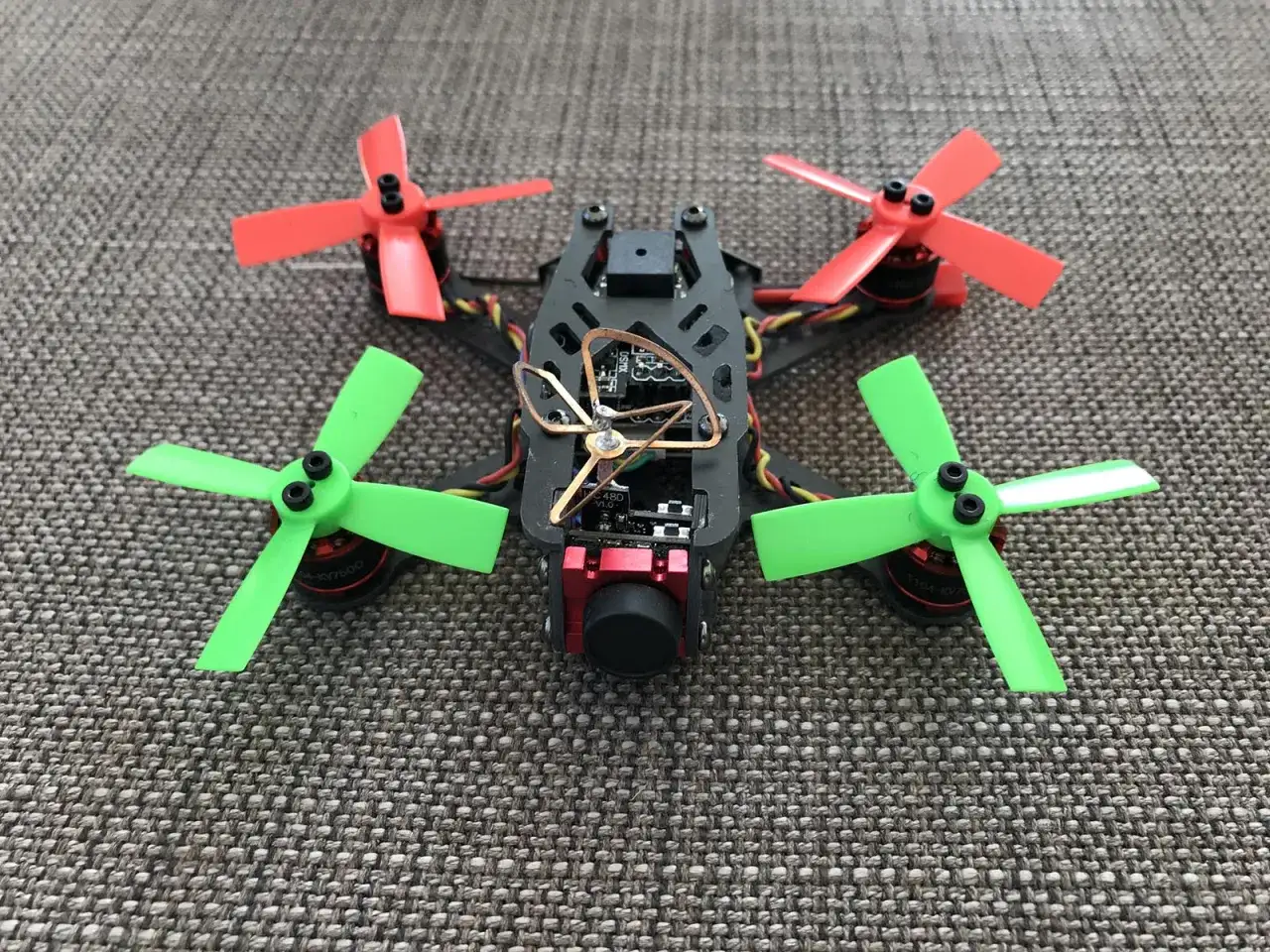 Ein FPV-Drohne mit roten und grünen Propellern, bereit für das FPV fliegen.