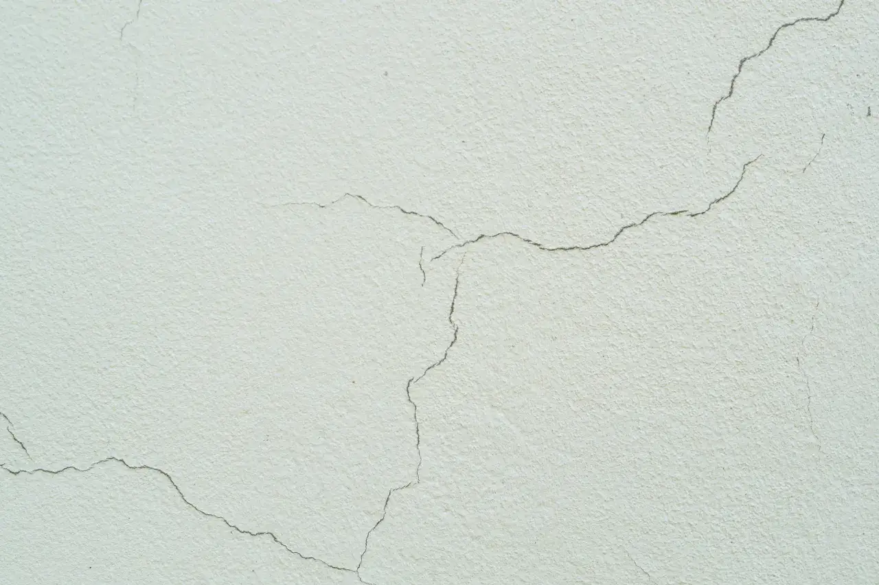 Textura de pared con monocapa en casas, mostrando finas grietas que revelan el paso del tiempo.