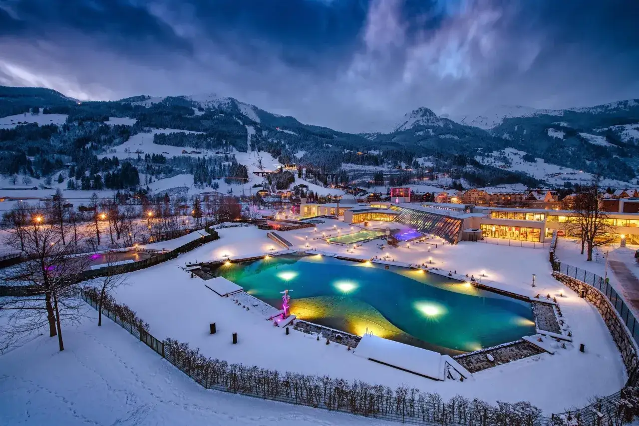 Vandra i Bad Gastein, ett snötäckt paradis med upplysta pooler och berg i bakgrunden.
